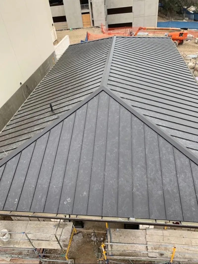 Commercial metal roof construction with crane equipment in Dove Valley